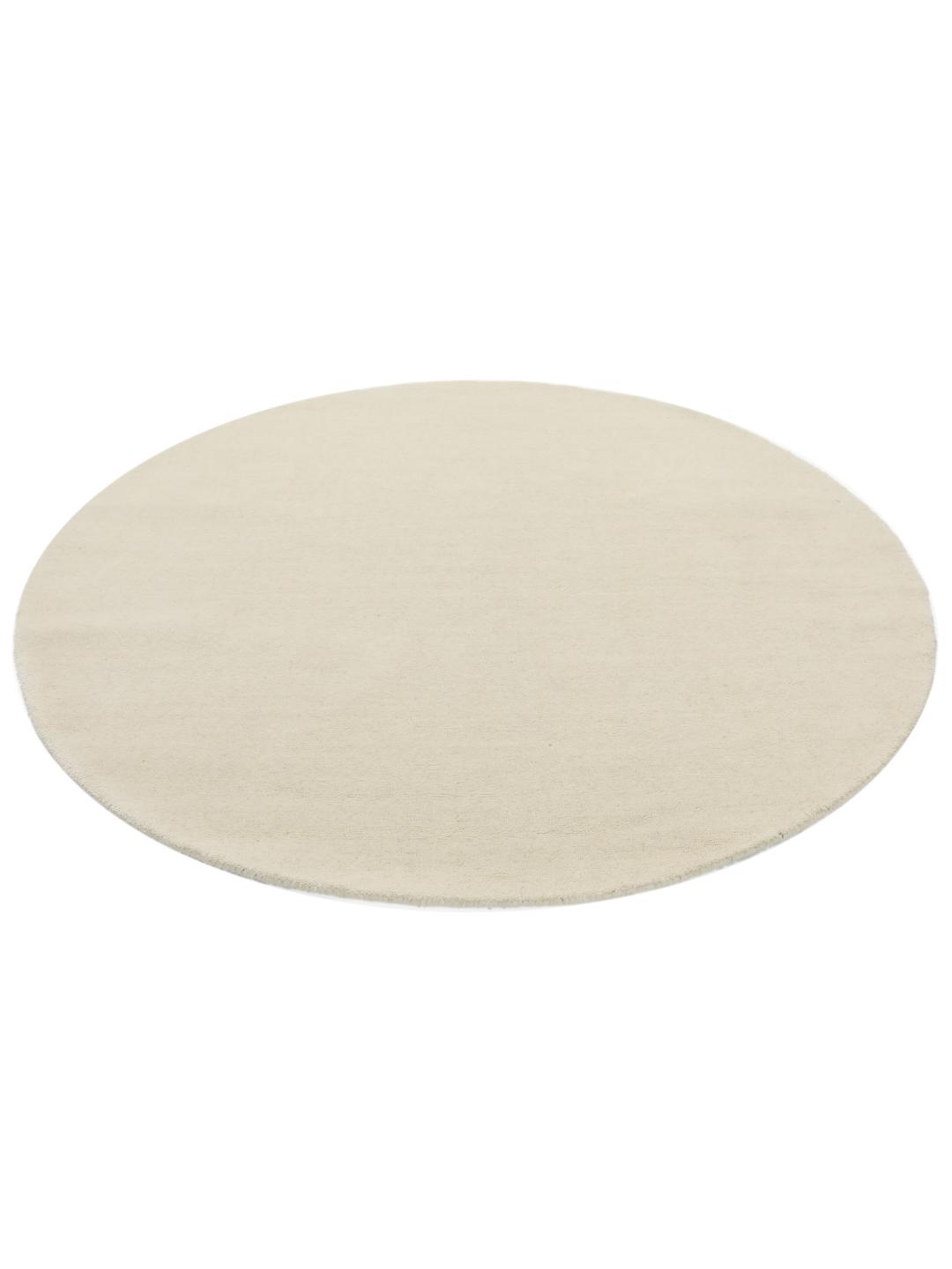 Een rond wit handgeweven vloerkleed gemaakt van wol