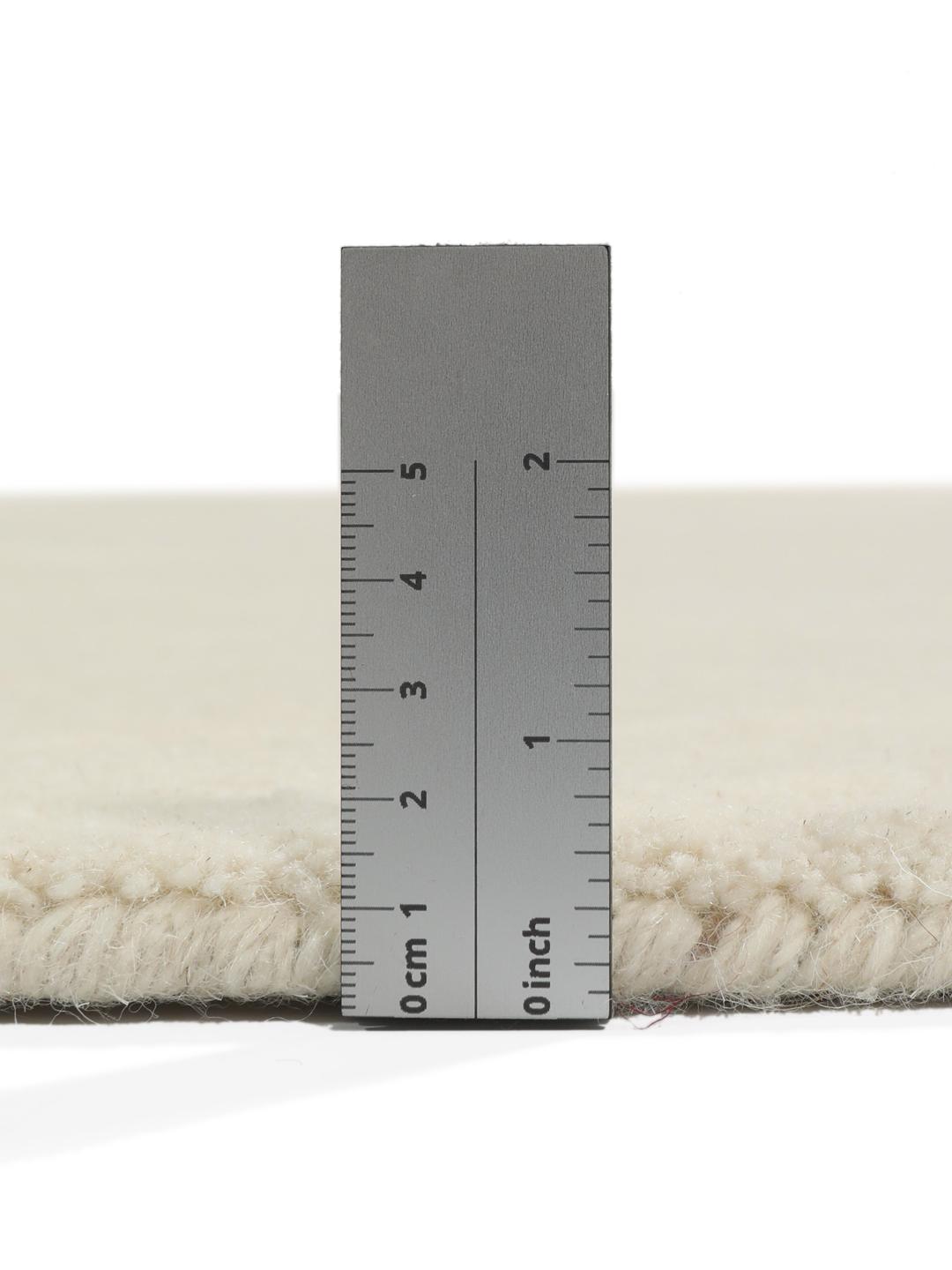 Een rond wit handgeweven vloerkleed gemaakt van wol