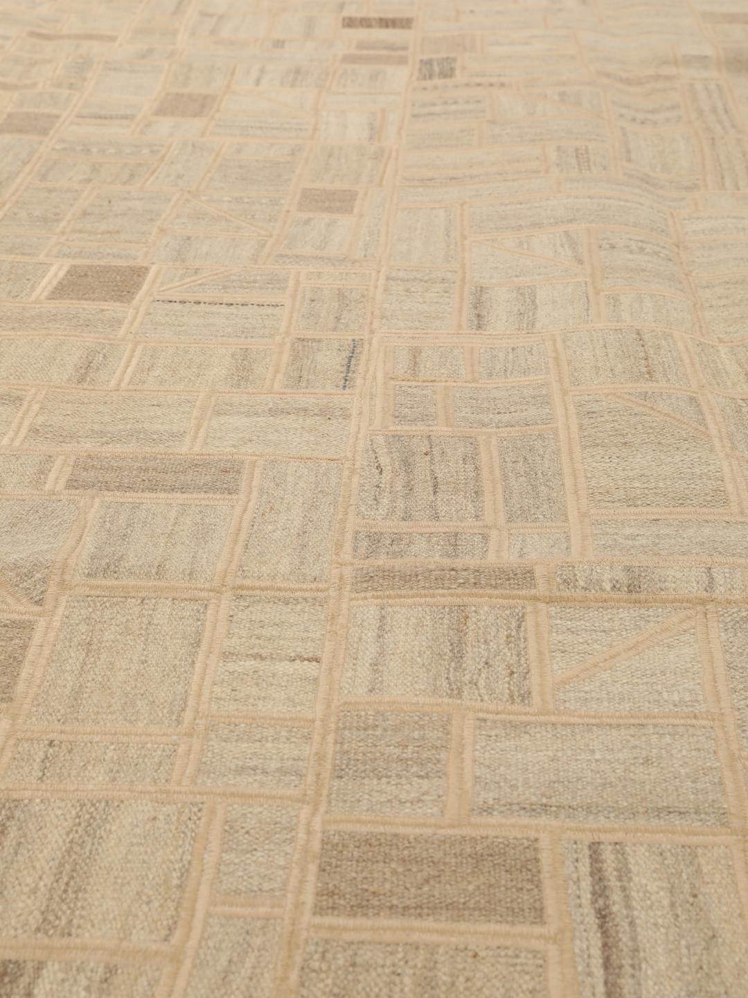 Een uniek rechthoekig patchwork tapijt met geometrische patronen in beige- en bruintinten.
