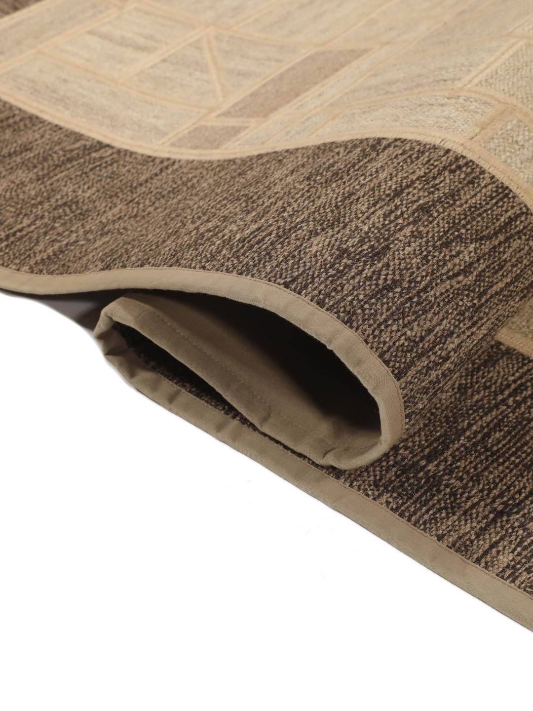 Een uniek rechthoekig patchwork tapijt met geometrische patronen in beige- en bruintinten.