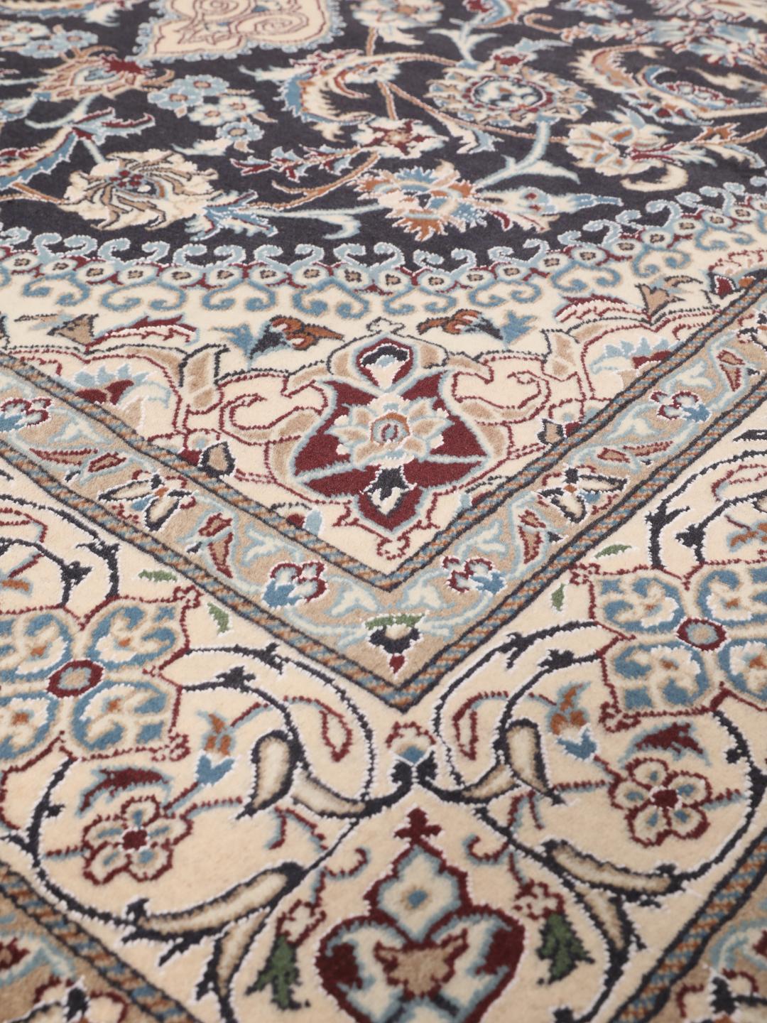 Hand-knotted Nain rug from the Middle East with a dark-blue and cream floral design.