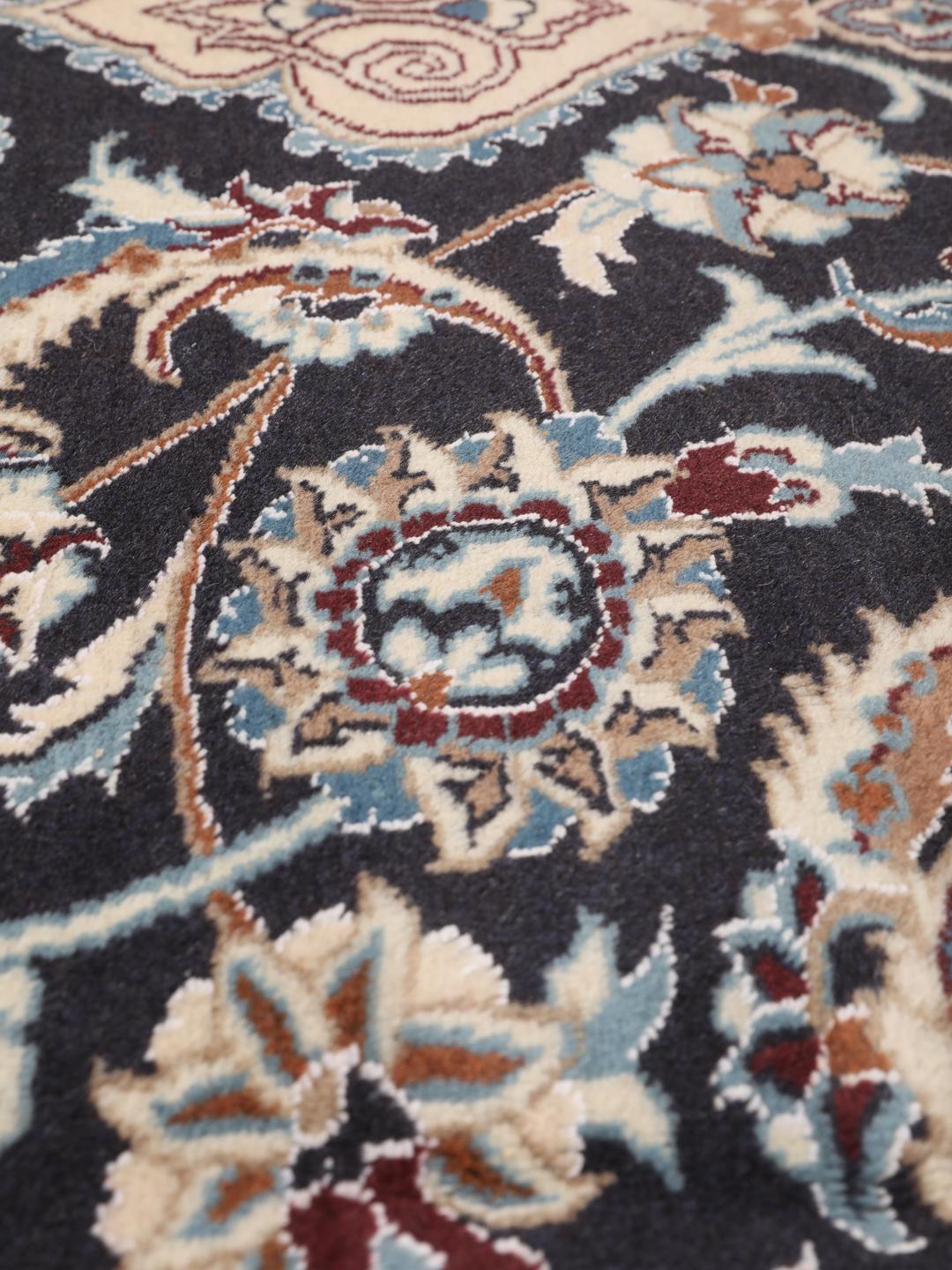 Hand-knotted Nain rug from the Middle East with a dark-blue and cream floral design.