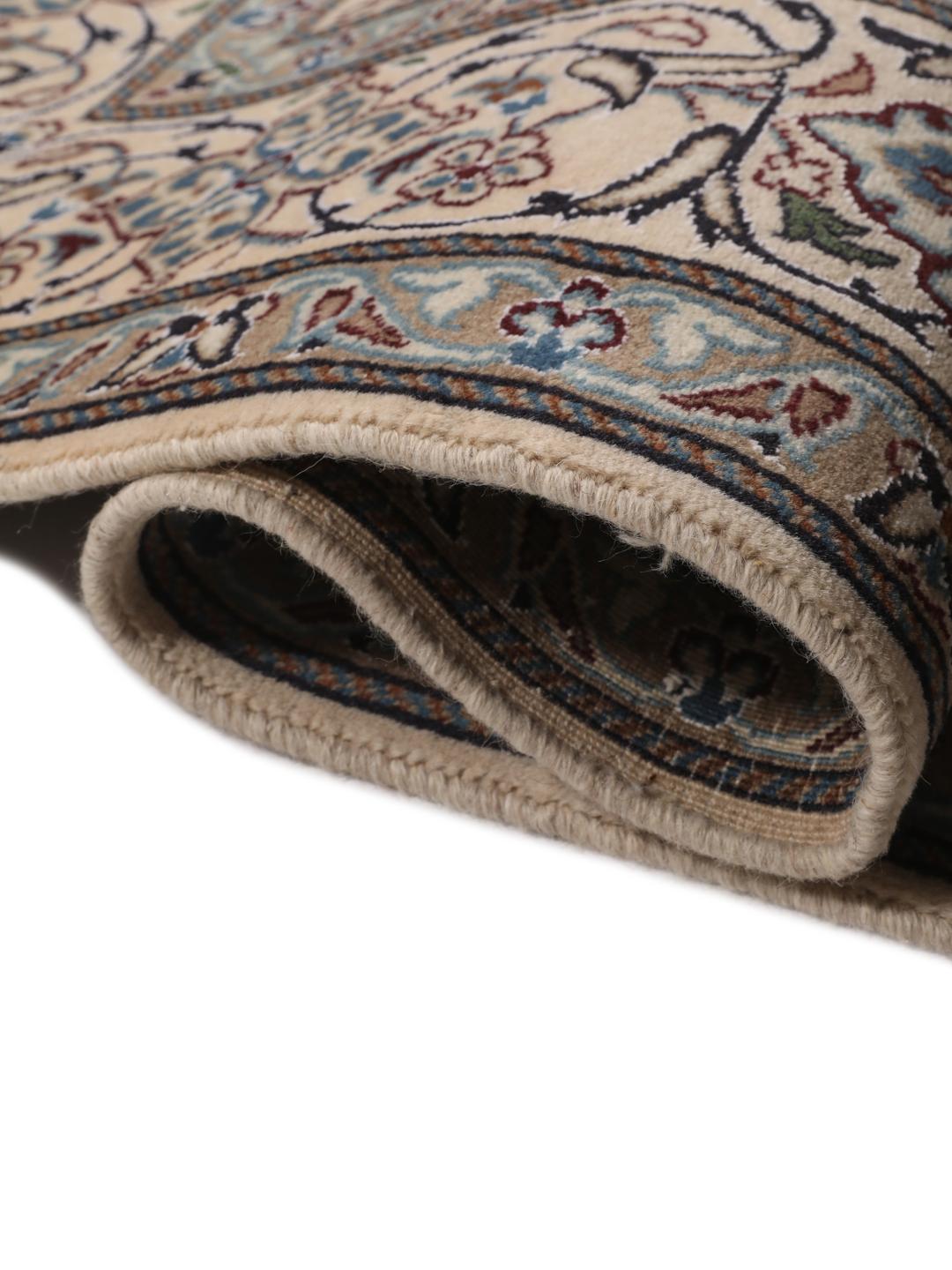Hand-knotted Nain rug from the Middle East with a dark-blue and cream floral design.