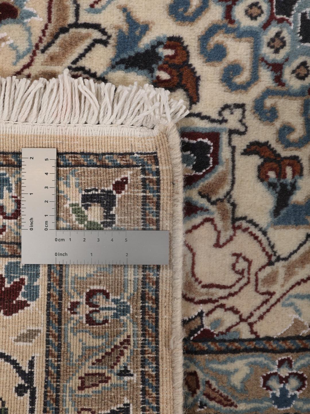 Hand-knotted Nain rug from the Middle East with a dark-blue and cream floral design.