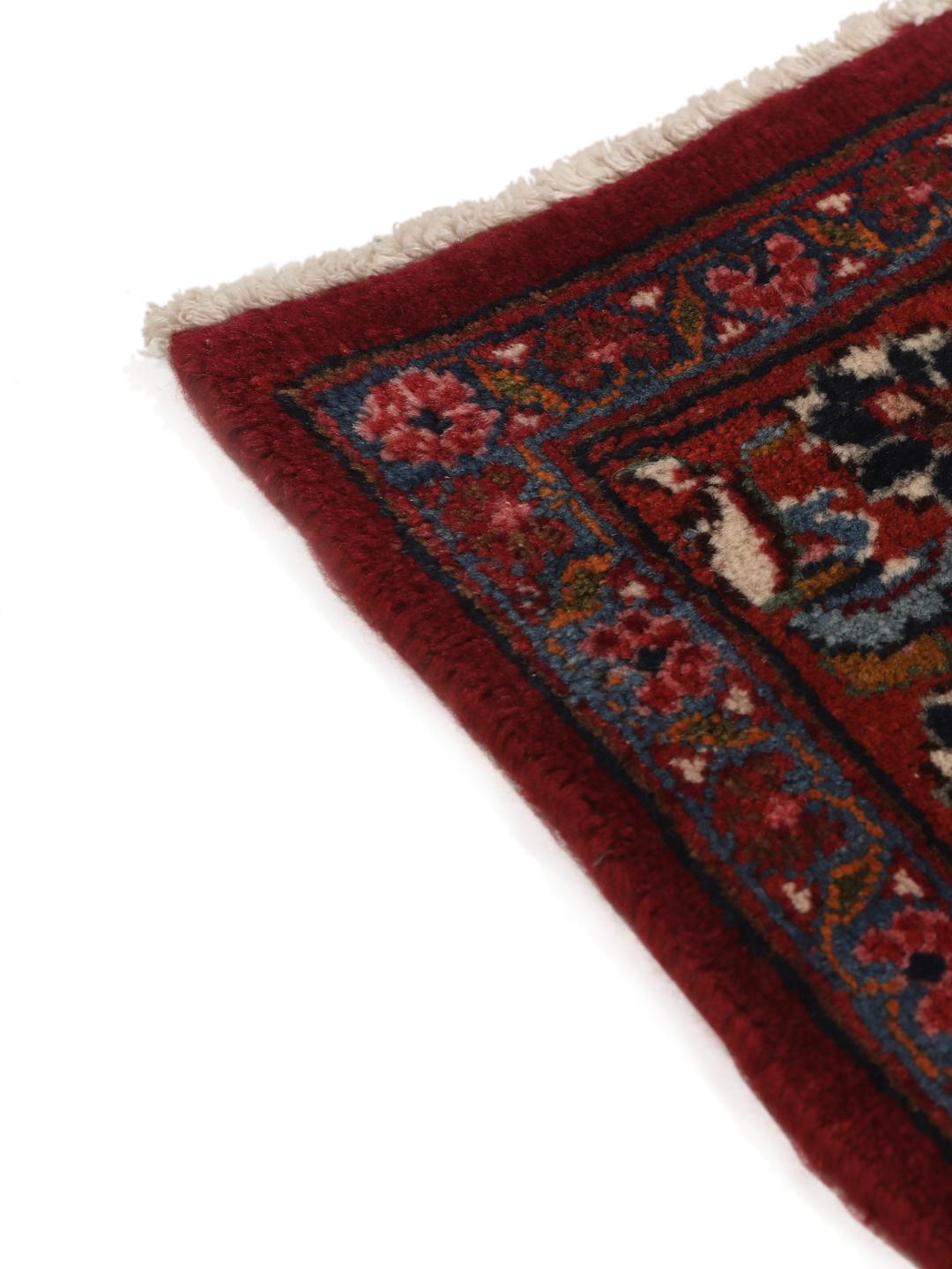 Hand-knotted Mashad rug from the Middle East in deep dark-red with floral pattern