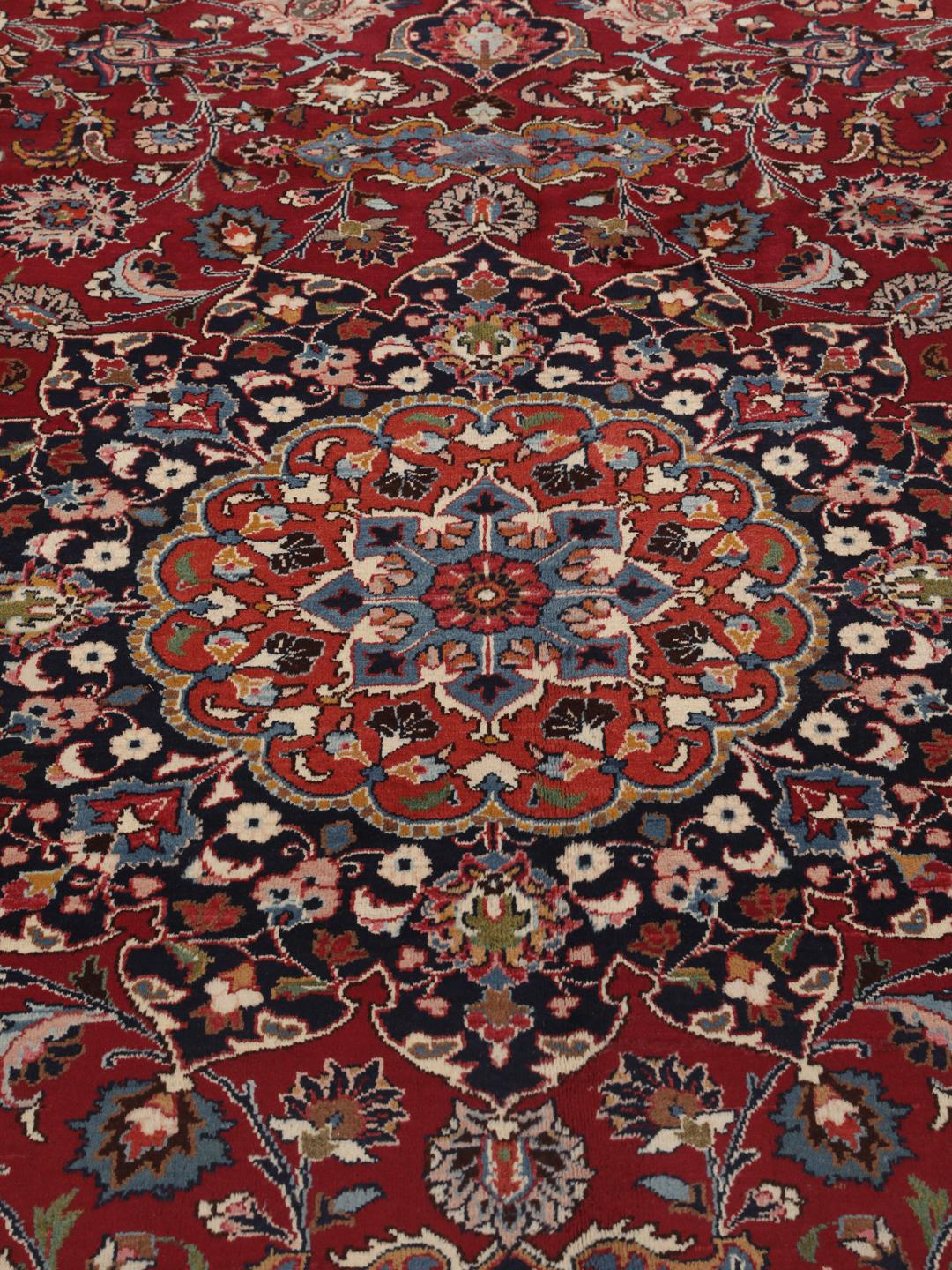 Hand-knotted Mashad rug from the Middle East in deep dark-red with floral pattern
