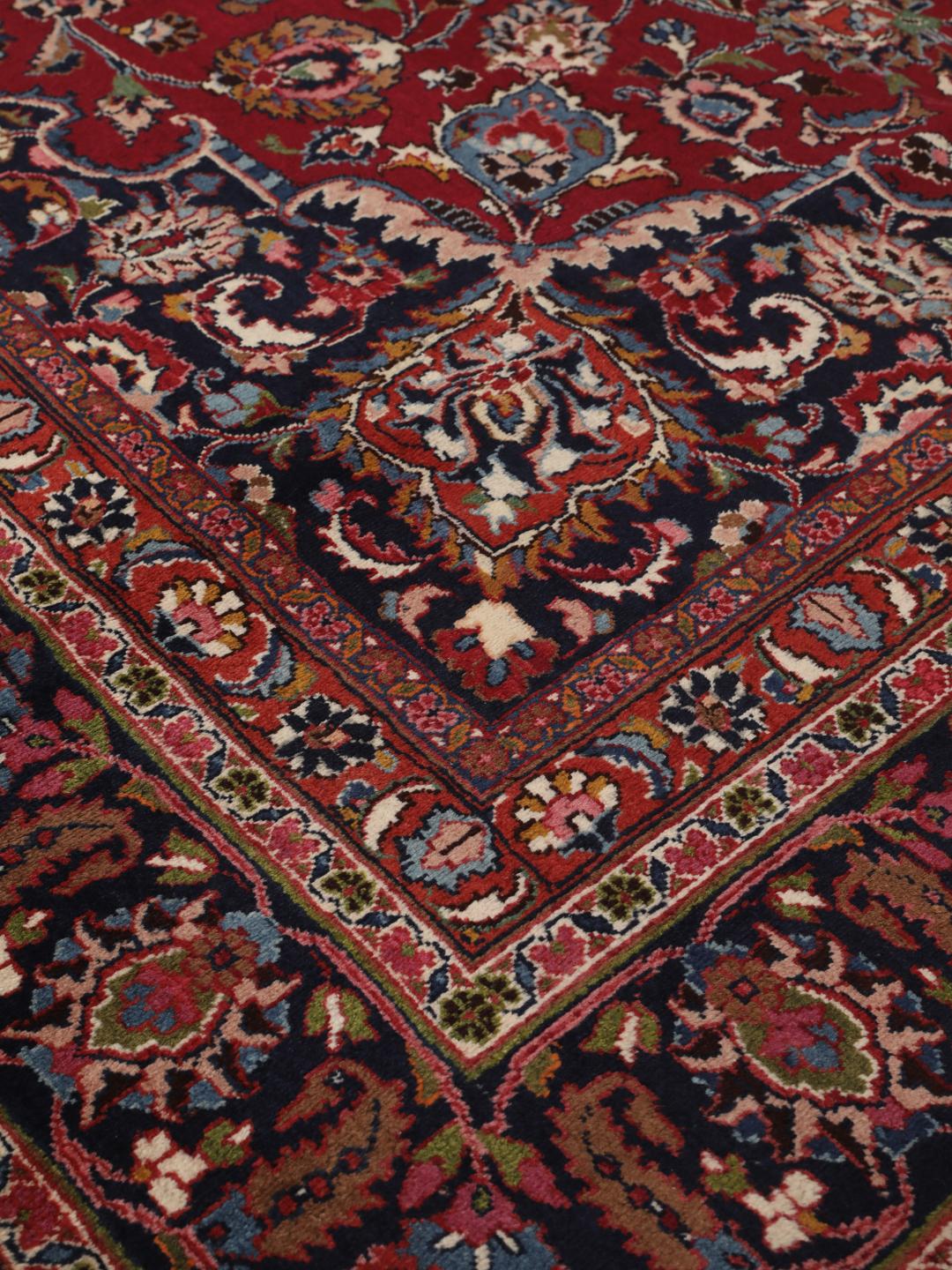 Hand-knotted Mashad rug from the Middle East in deep dark-red with floral pattern