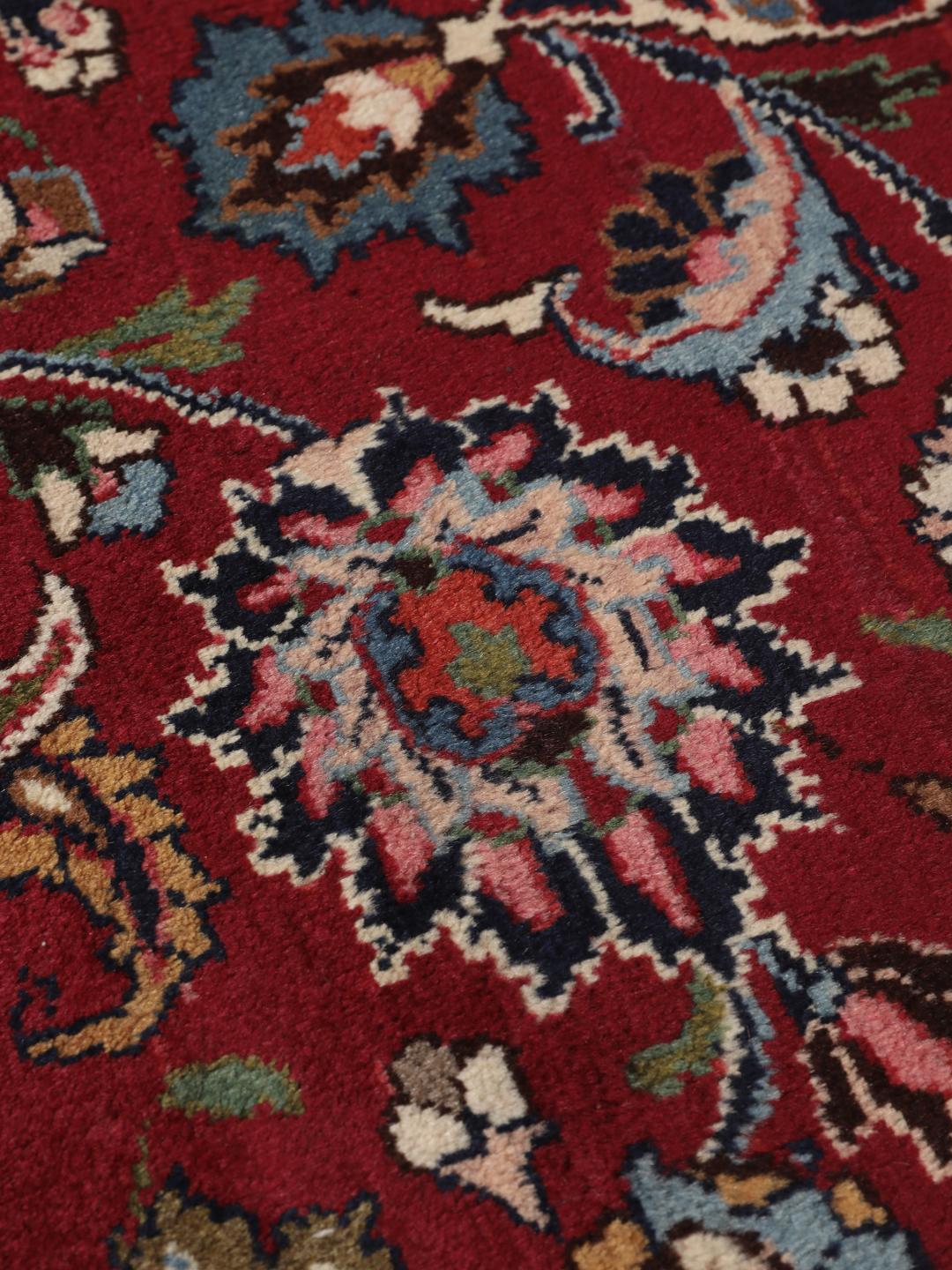 Hand-knotted Mashad rug from the Middle East in deep dark-red with floral pattern