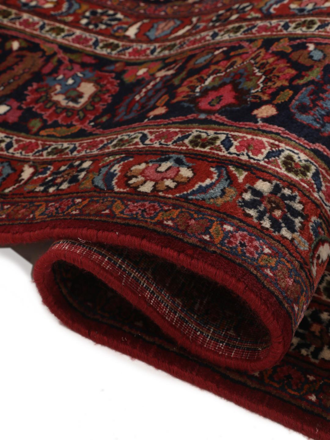Hand-knotted Mashad rug from the Middle East in deep dark-red with floral pattern