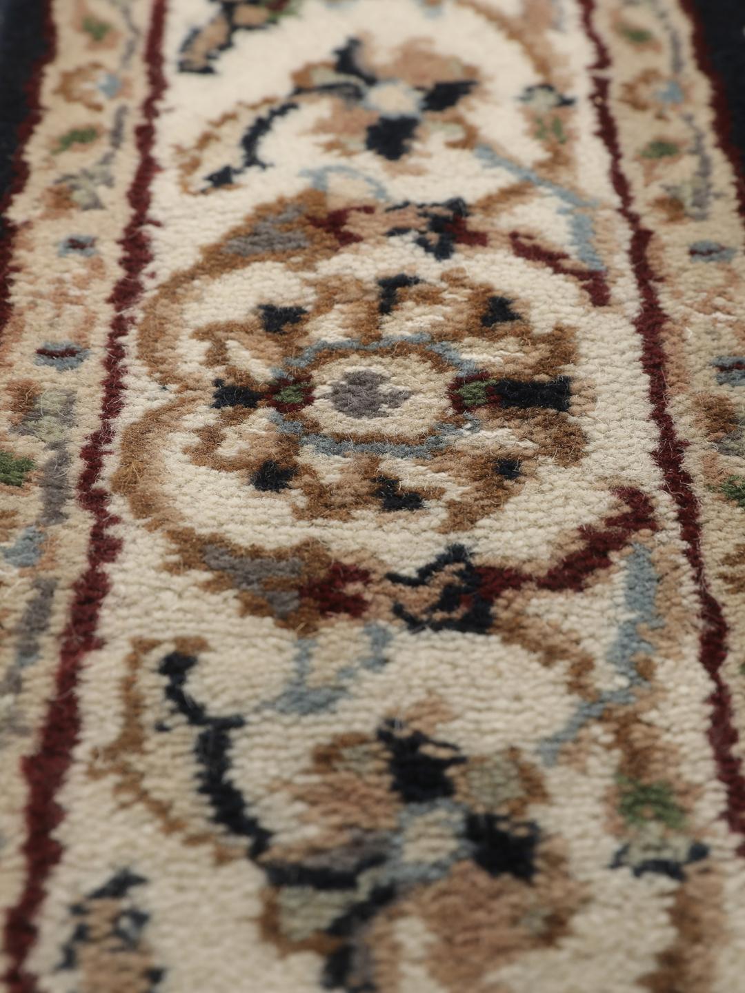 En håndknyttet Nain Indo løber fra Indien med et sofistikeret sort felt og indviklede blomstermotiver.