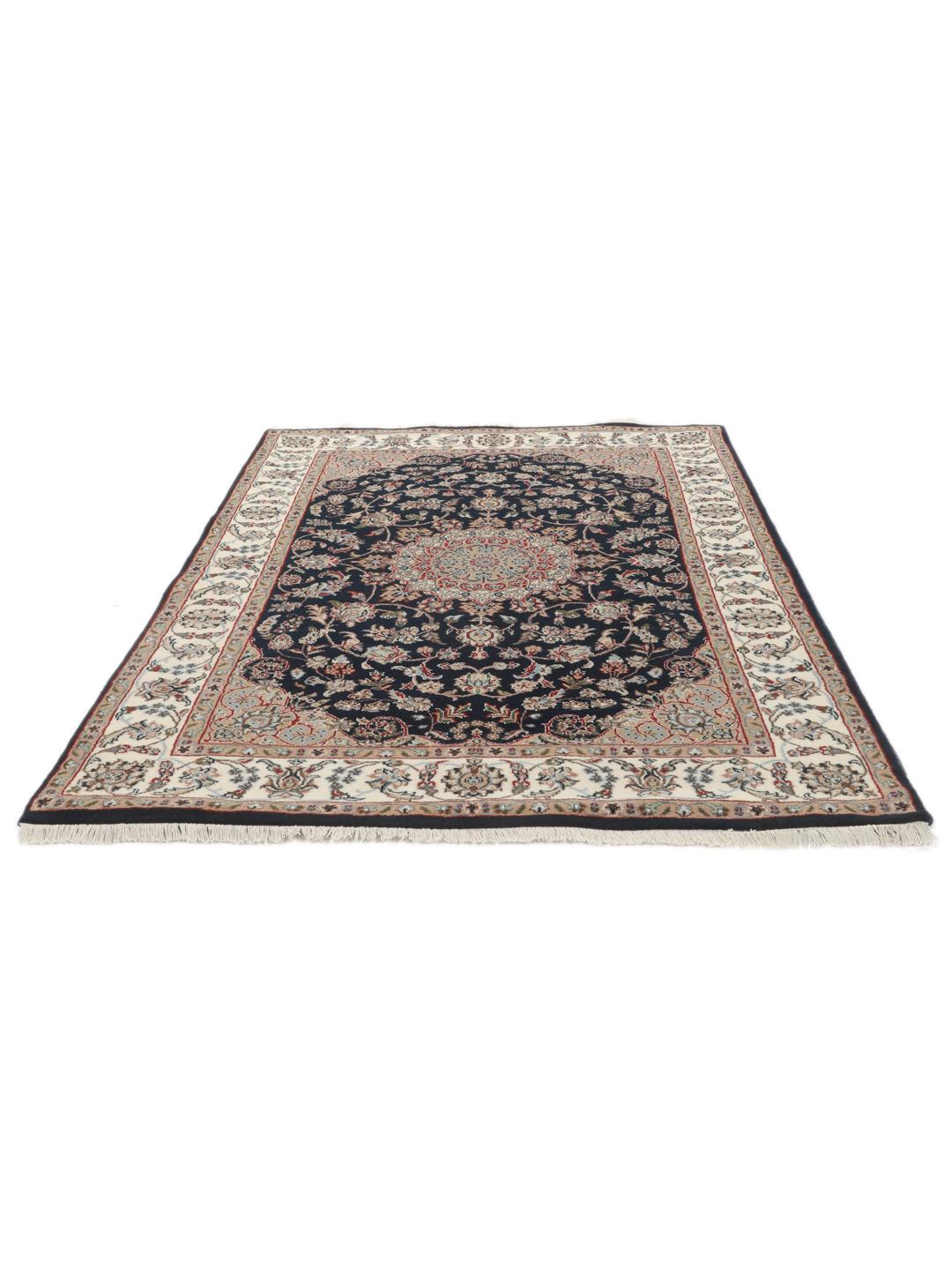 Un tapis rectangulaire Nain Indo présentant un champ bleu foncé avec un médaillon floral central et des bordures complexes, noué à la main en Inde.