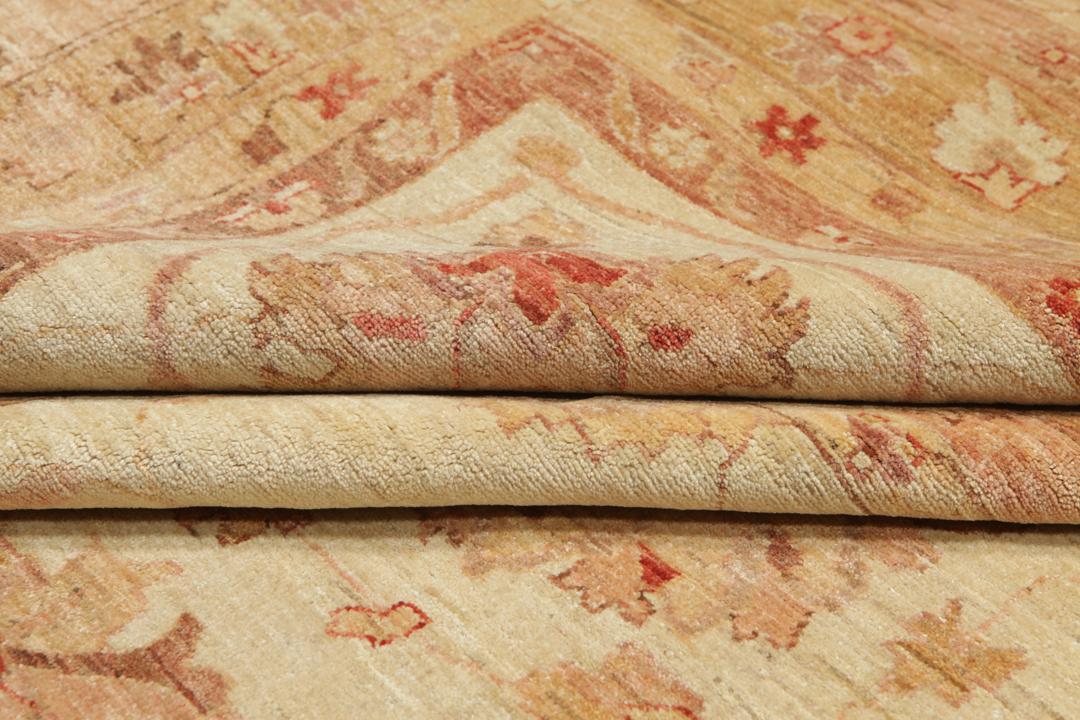A large, hand-knotted Ziegler rug from Pakistan featuring a neutral beige and soft red floral pattern.