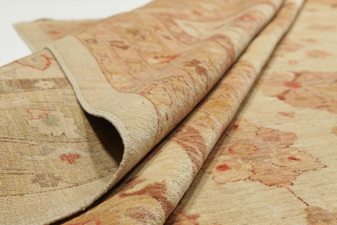 A large, hand-knotted Ziegler rug from Pakistan featuring a neutral beige and soft red floral pattern.