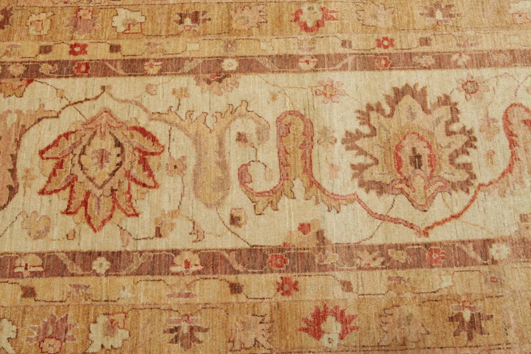 A large, hand-knotted Ziegler rug from Pakistan featuring a neutral beige and soft red floral pattern.