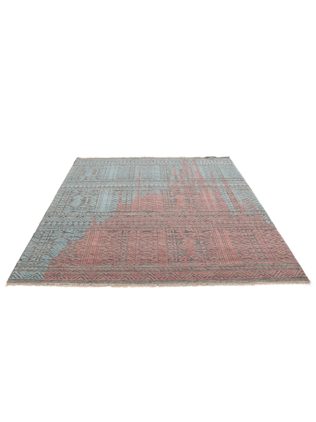 Een modern handgeknoopt Indiaas tapijt met een meerkleurig ontwerp in blauwgroene en aardse tinten.