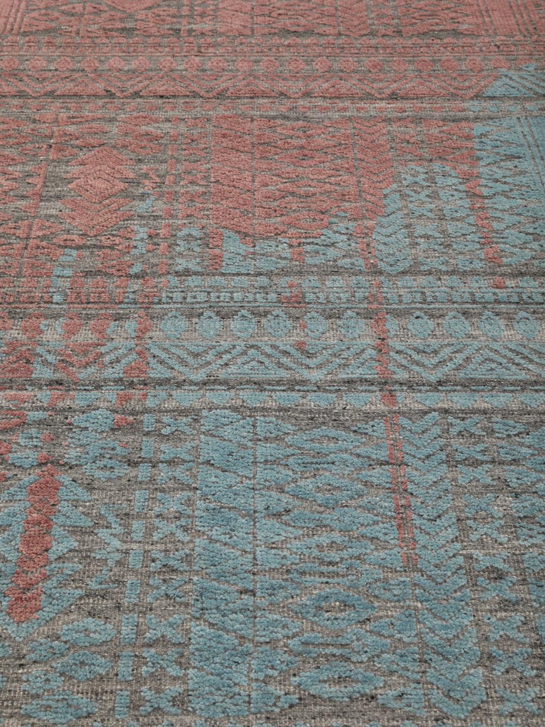 Een modern handgeknoopt Indiaas tapijt met een meerkleurig ontwerp in blauwgroene en aardse tinten.