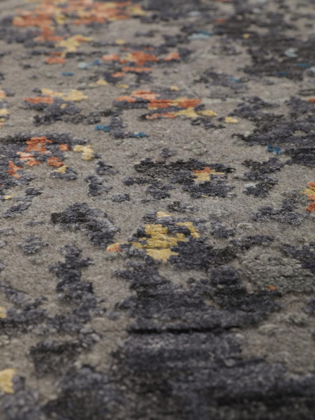 Een modern handgeknoopt tapijt uit India met een abstract ontwerp in grijze, blauwe en oranje tinten.