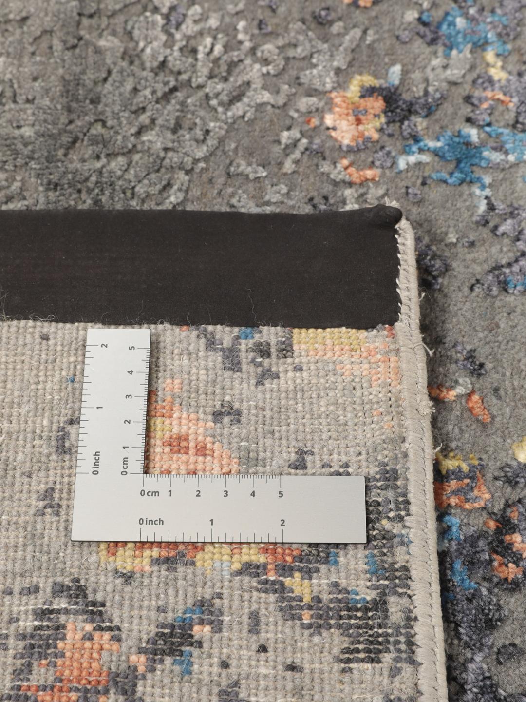 Een modern handgeknoopt tapijt uit India met een abstract ontwerp in grijze, blauwe en oranje tinten.