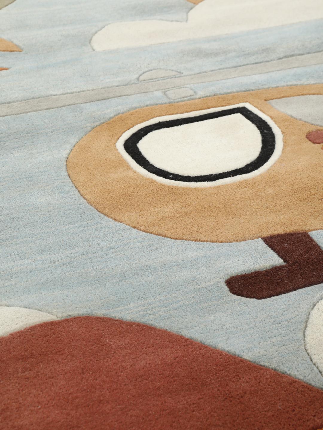 Tapis bleu clair avec des motifs ludiques d'avions et de montgolfières