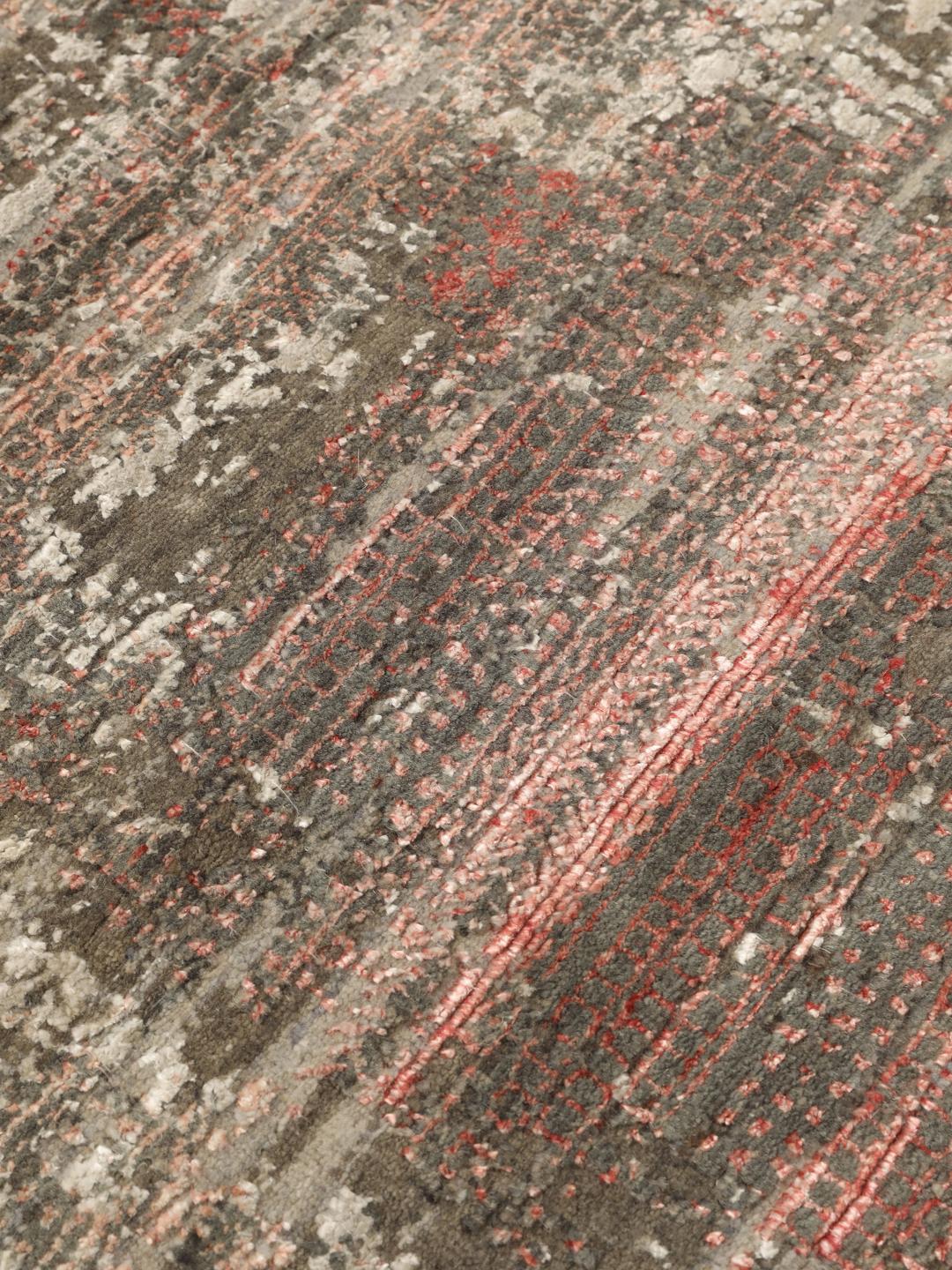 Et moderne håndknyttet tæppe fra Indien med et abstrakt design i grå og røde toner.