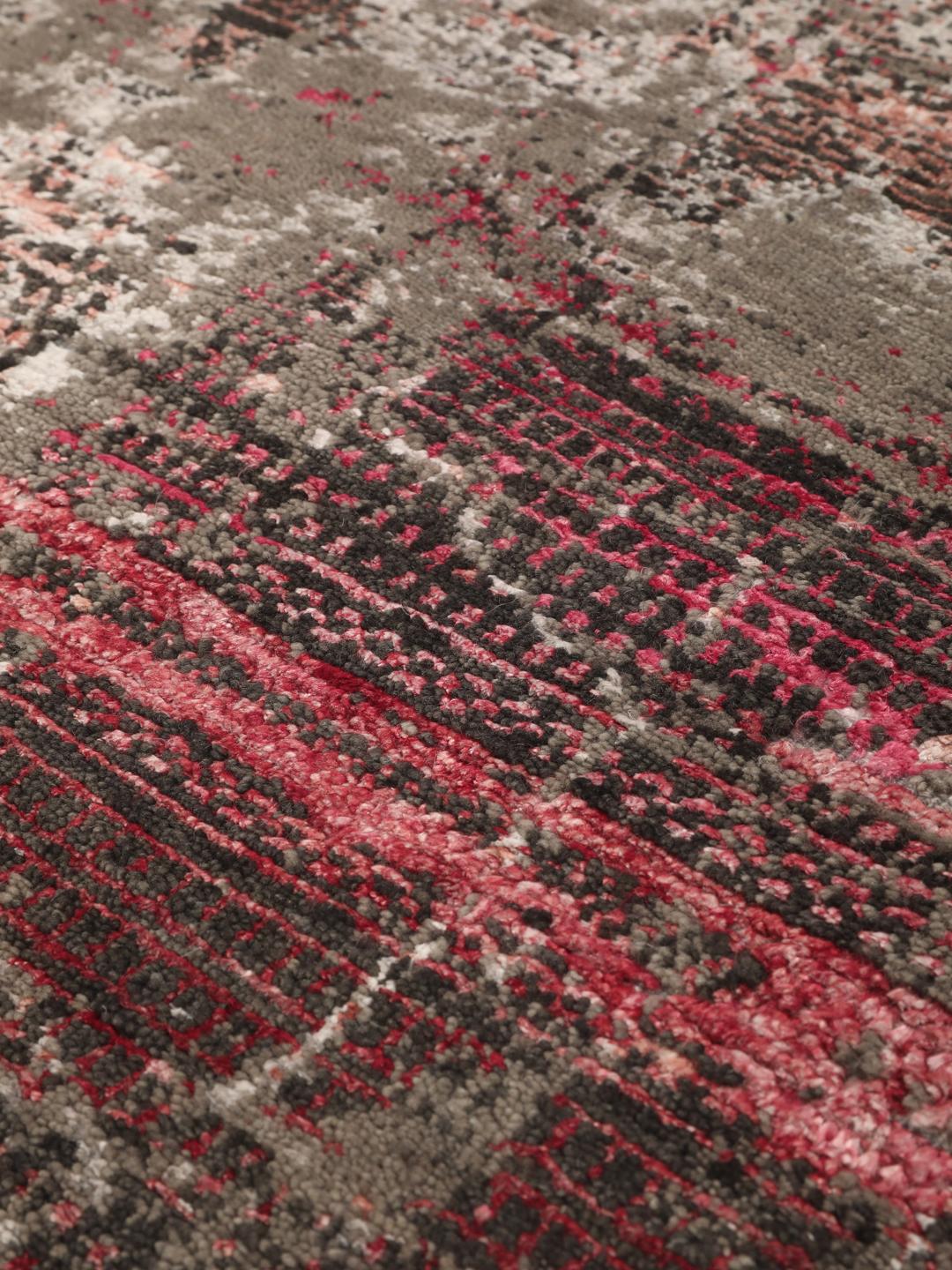 Et moderne håndknyttet tæppe fra Indien med et gråt og pink abstrakt design.