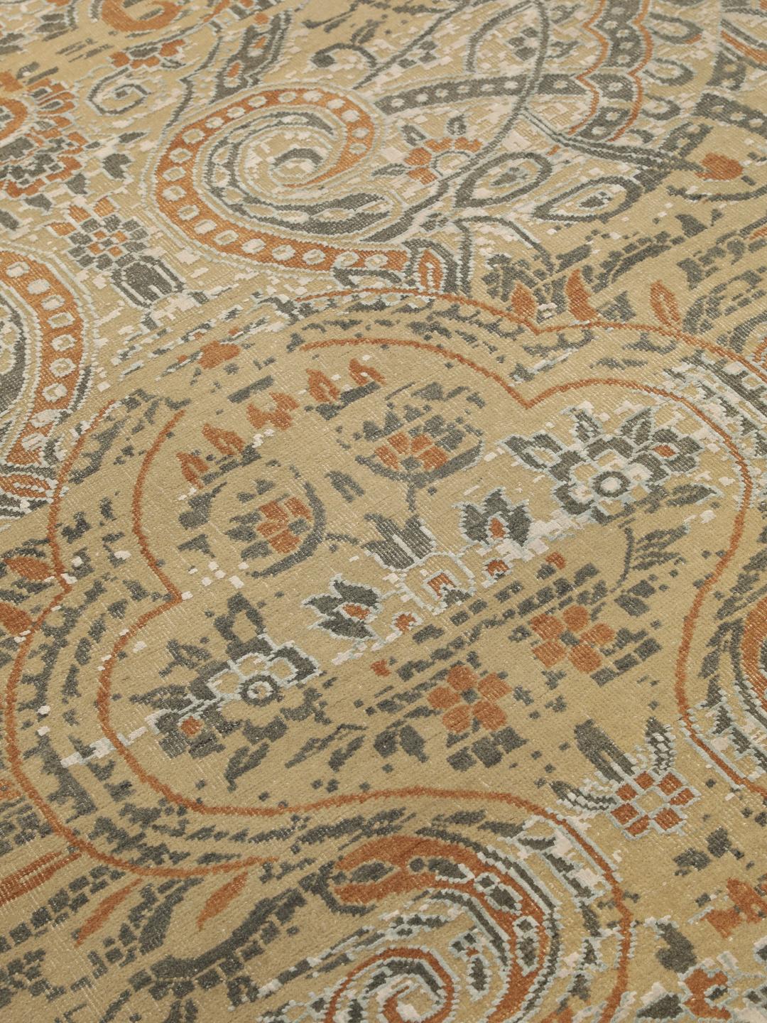 Håndknyttet indisk tæppe med et moderne blomstermønster i beige og orange toner.
