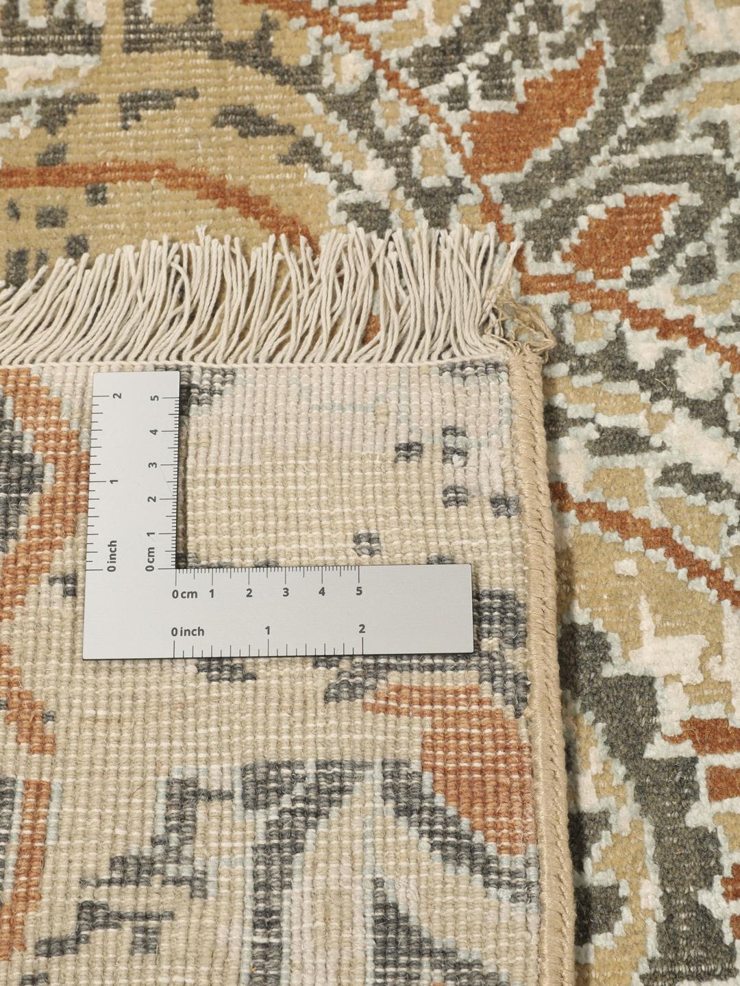 Håndknyttet indisk tæppe med et moderne blomstermønster i beige og orange toner.