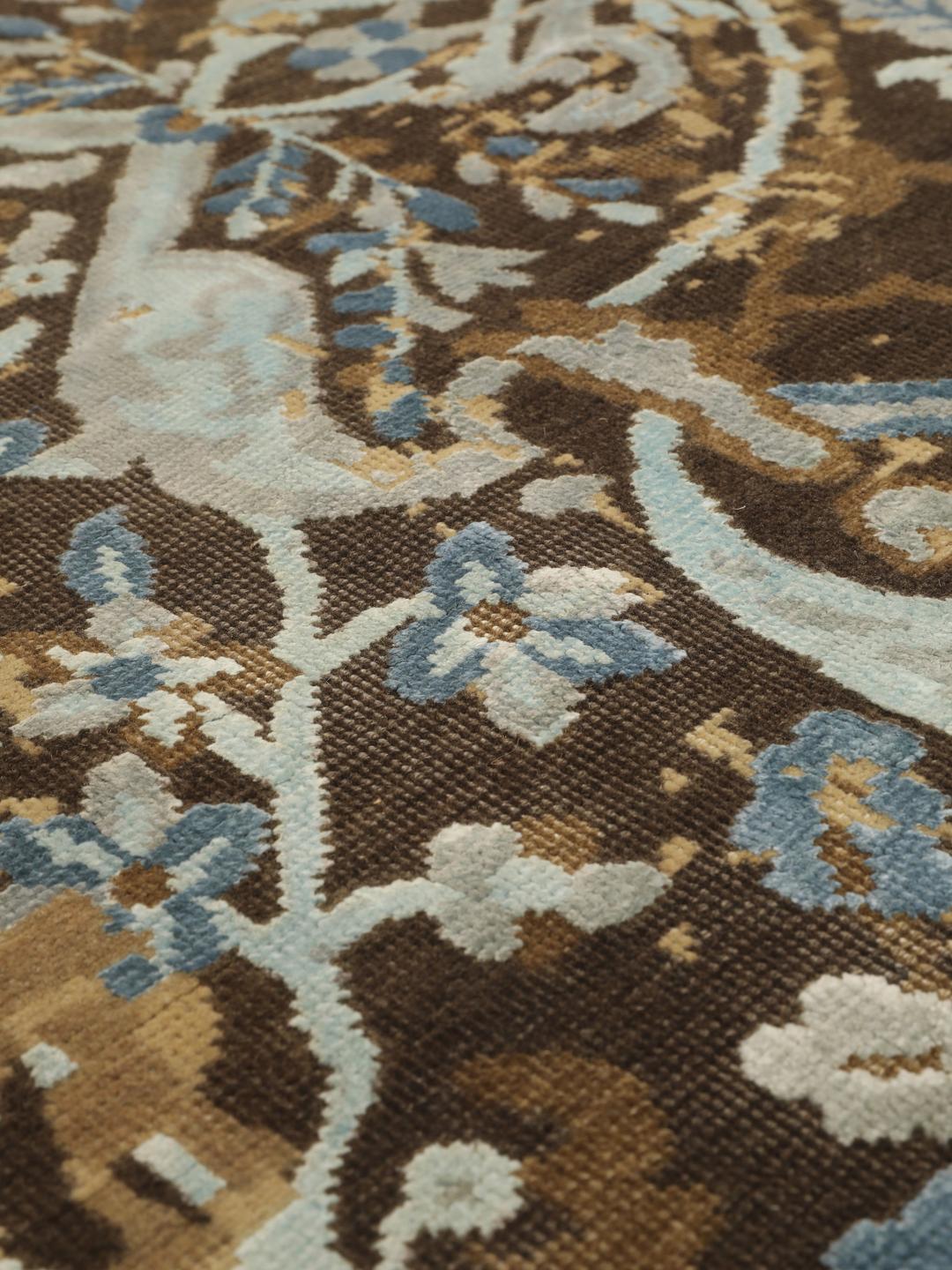 Håndknyttet moderne tæppe fra Indien med et slidt blomstermønster i beige, brun og blå.