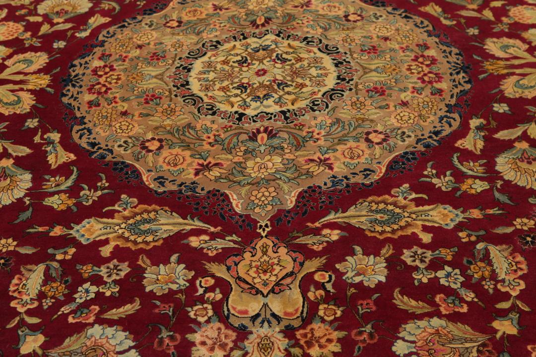 Hand-knotted Tabriz rug from the Middle East featuring a vibrant red field and intricate floral patterns.