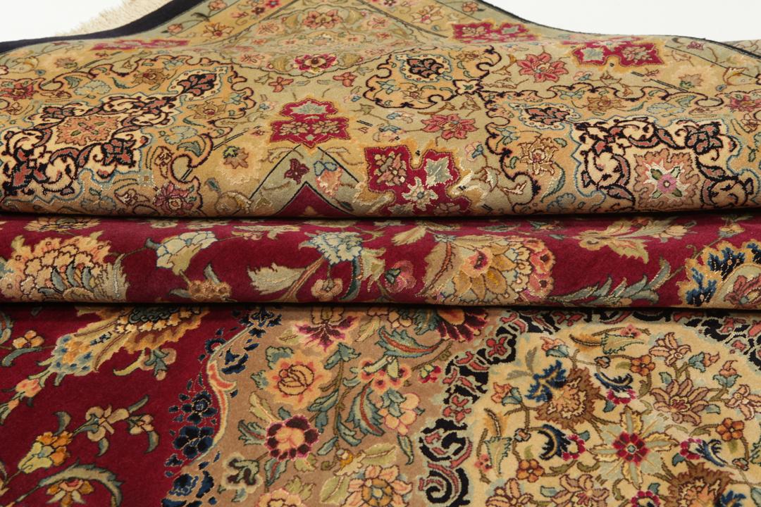 Hand-knotted Tabriz rug from the Middle East featuring a vibrant red field and intricate floral patterns.