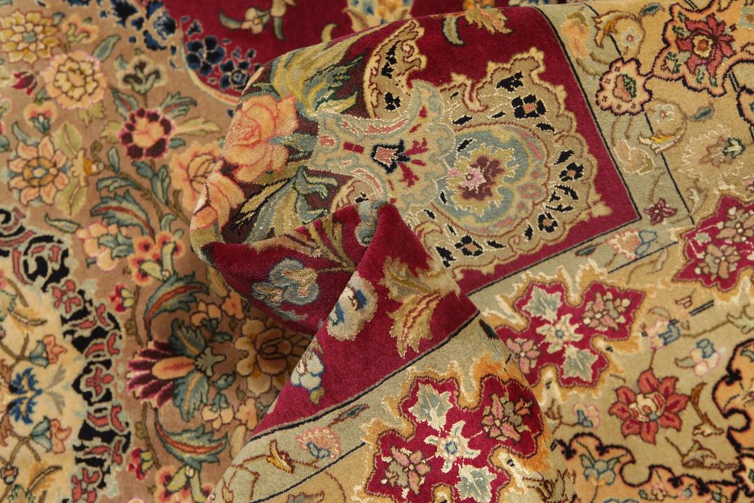Hand-knotted Tabriz rug from the Middle East featuring a vibrant red field and intricate floral patterns.