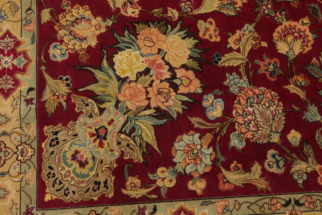 Hand-knotted Tabriz rug from the Middle East featuring a vibrant red field and intricate floral patterns.