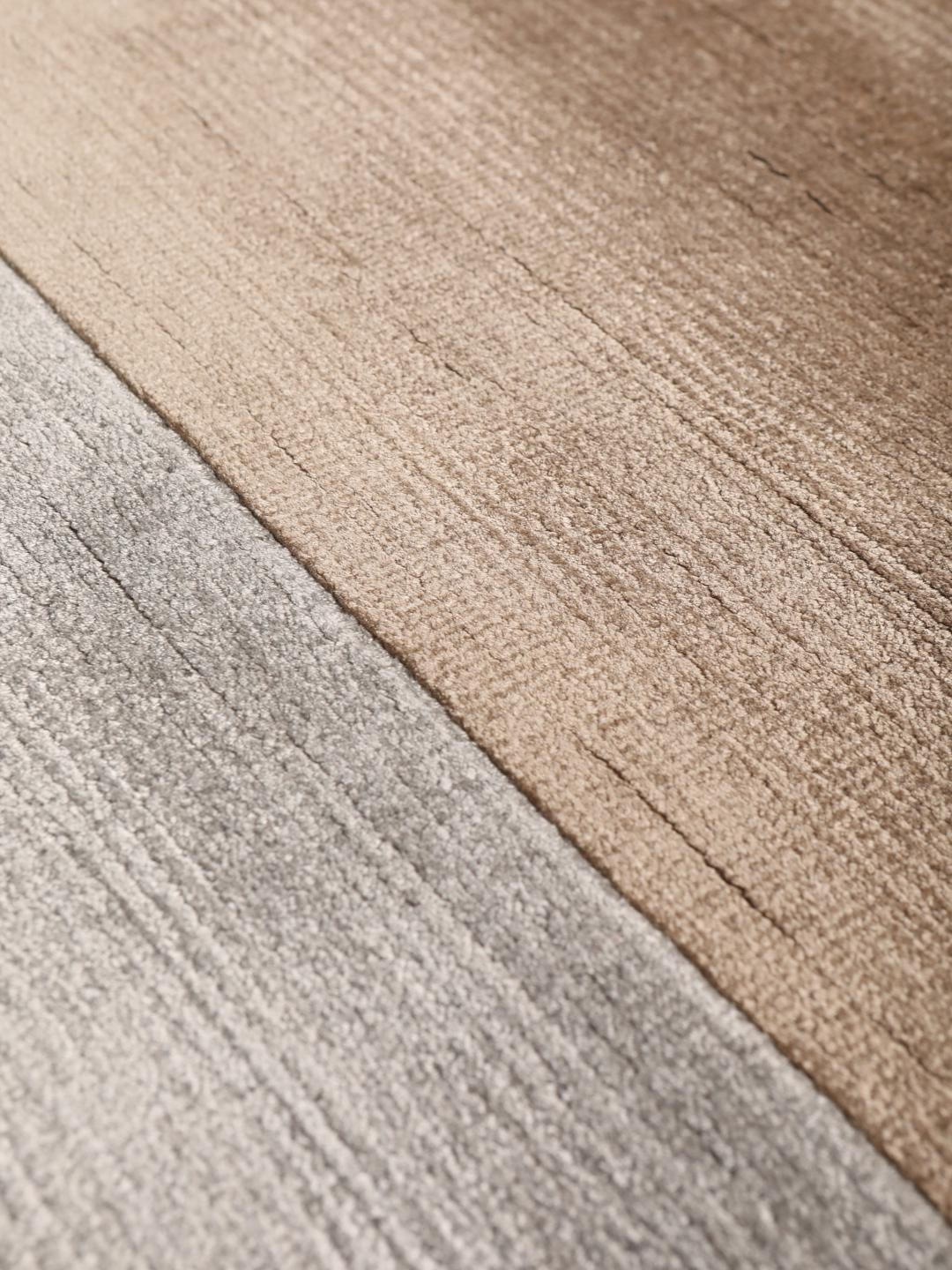 Handgeknoopt modern tapijt uit India in beige en grijze tinten.