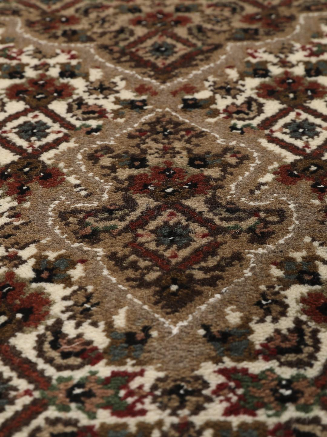 Et rundt, håndknyttet Tabriz-tæppe med detaljeret medaljon og blomstermotiver i brun og creme fra Indien.