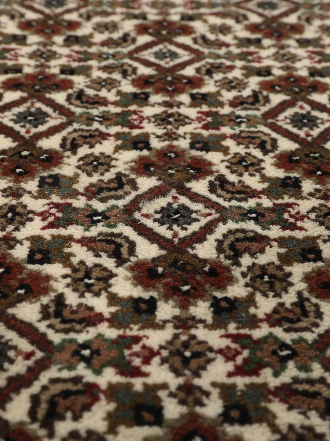 Et rundt, håndknyttet Tabriz-tæppe med detaljeret medaljon og blomstermotiver i brun og creme fra Indien.
