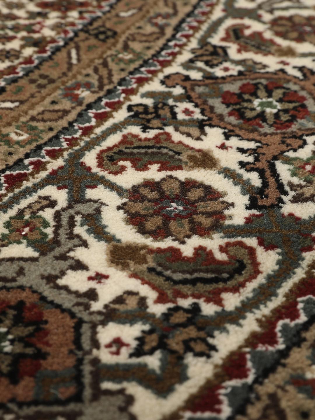 Et rundt, håndknyttet Tabriz-tæppe med detaljeret medaljon og blomstermotiver i brun og creme fra Indien.