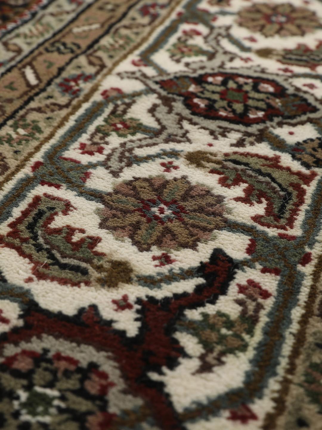 Ręcznie wiązany dywan Tabriz z Indii z ozdobnym wzorem kwiatowego medalionu w odcieniach ciemnej czerwieni i beżu.