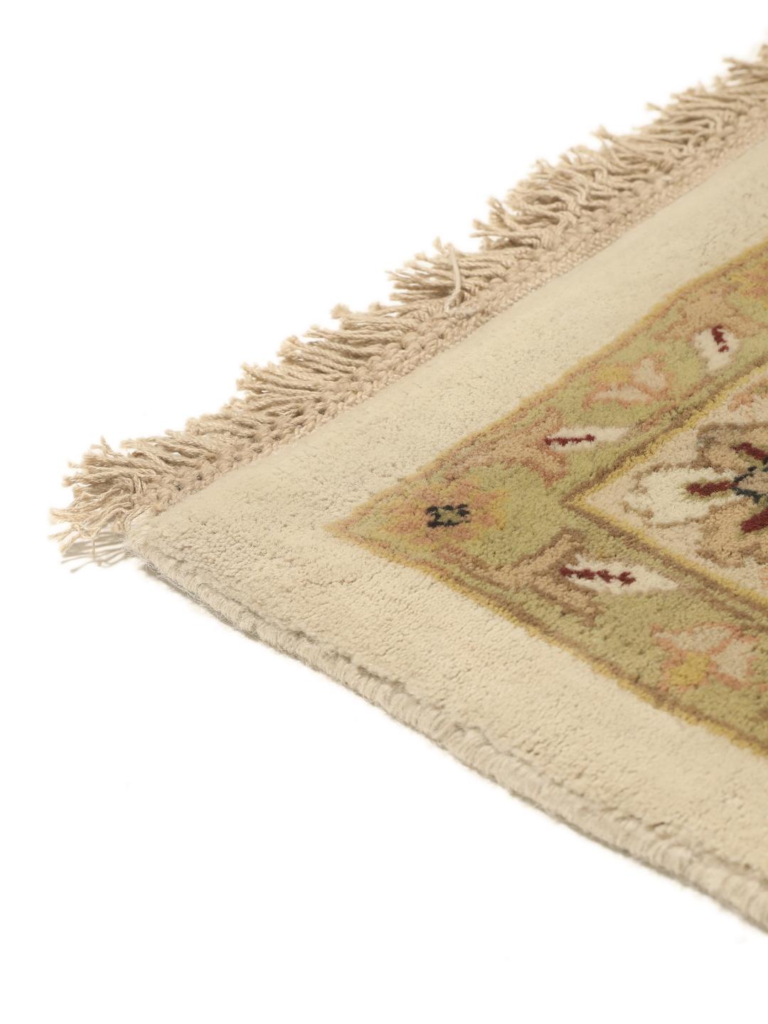 A large, hand-knotted Sarough rug from India featuring an intricate floral design on a beige field with a black border.