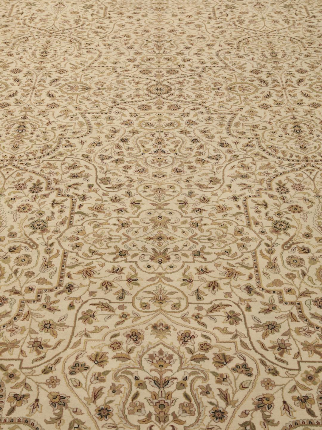 A large, hand-knotted Sarough rug from India featuring an intricate floral design on a beige field with a black border.