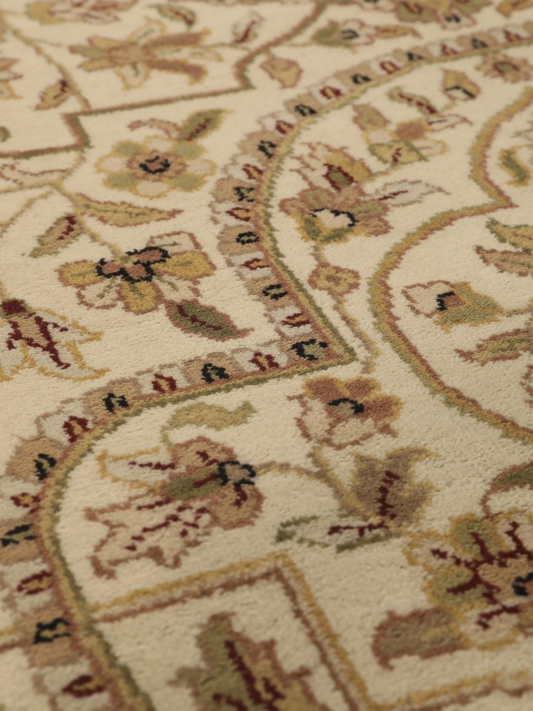 A large, hand-knotted Sarough rug from India featuring an intricate floral design on a beige field with a black border.