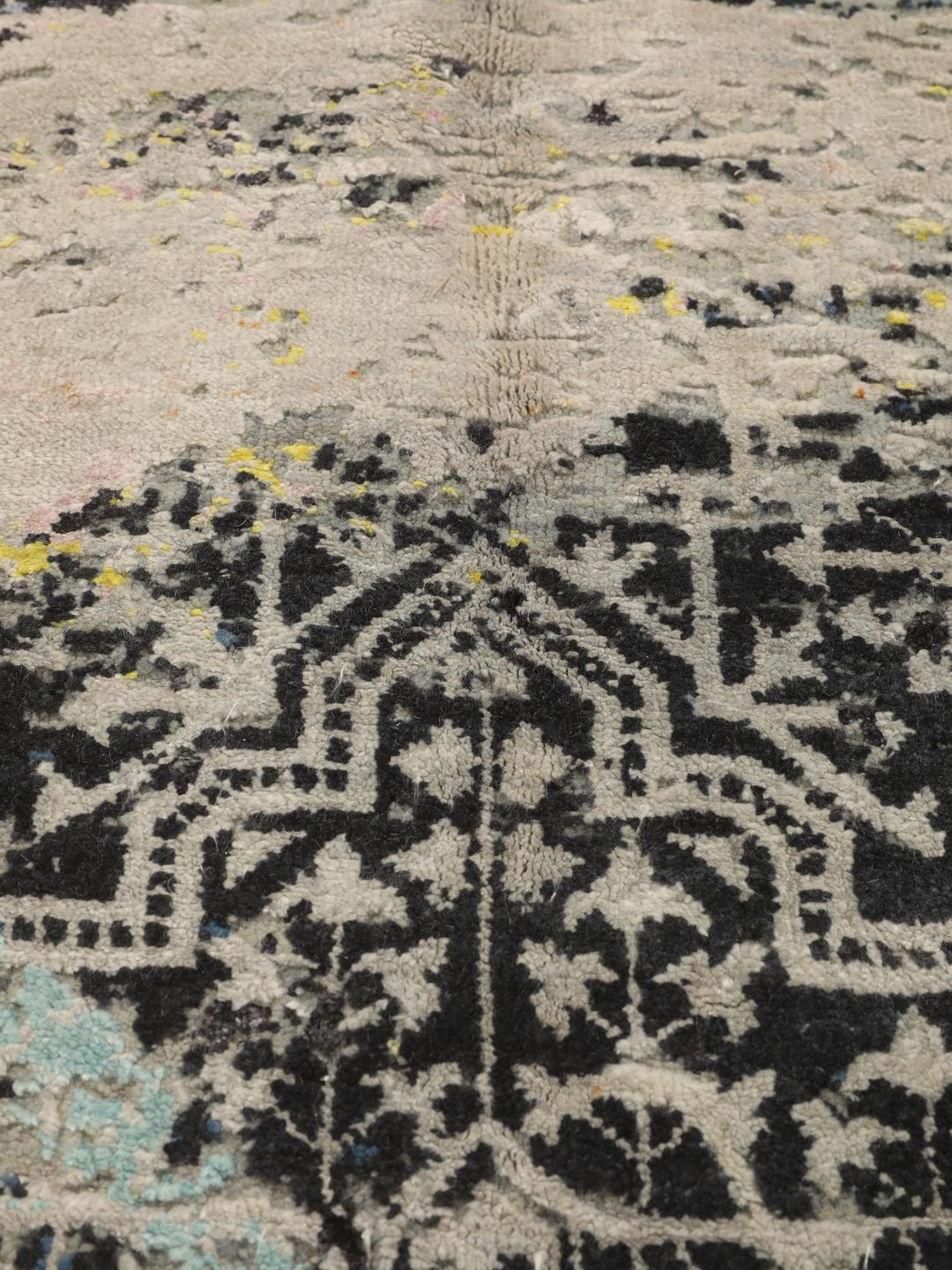 Et håndknyttet moderne tæppe fra Indien med et abstrakt design i blå, sorte og lyse nuancer.
