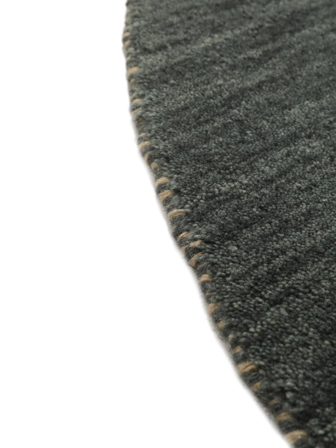 Rond vloerkleed met een donkergroene basis en gele diermotieven