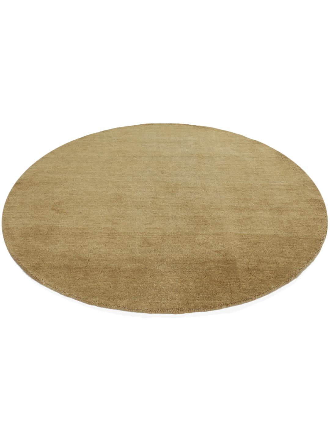 A round beige handloom rug with a soft wool pile