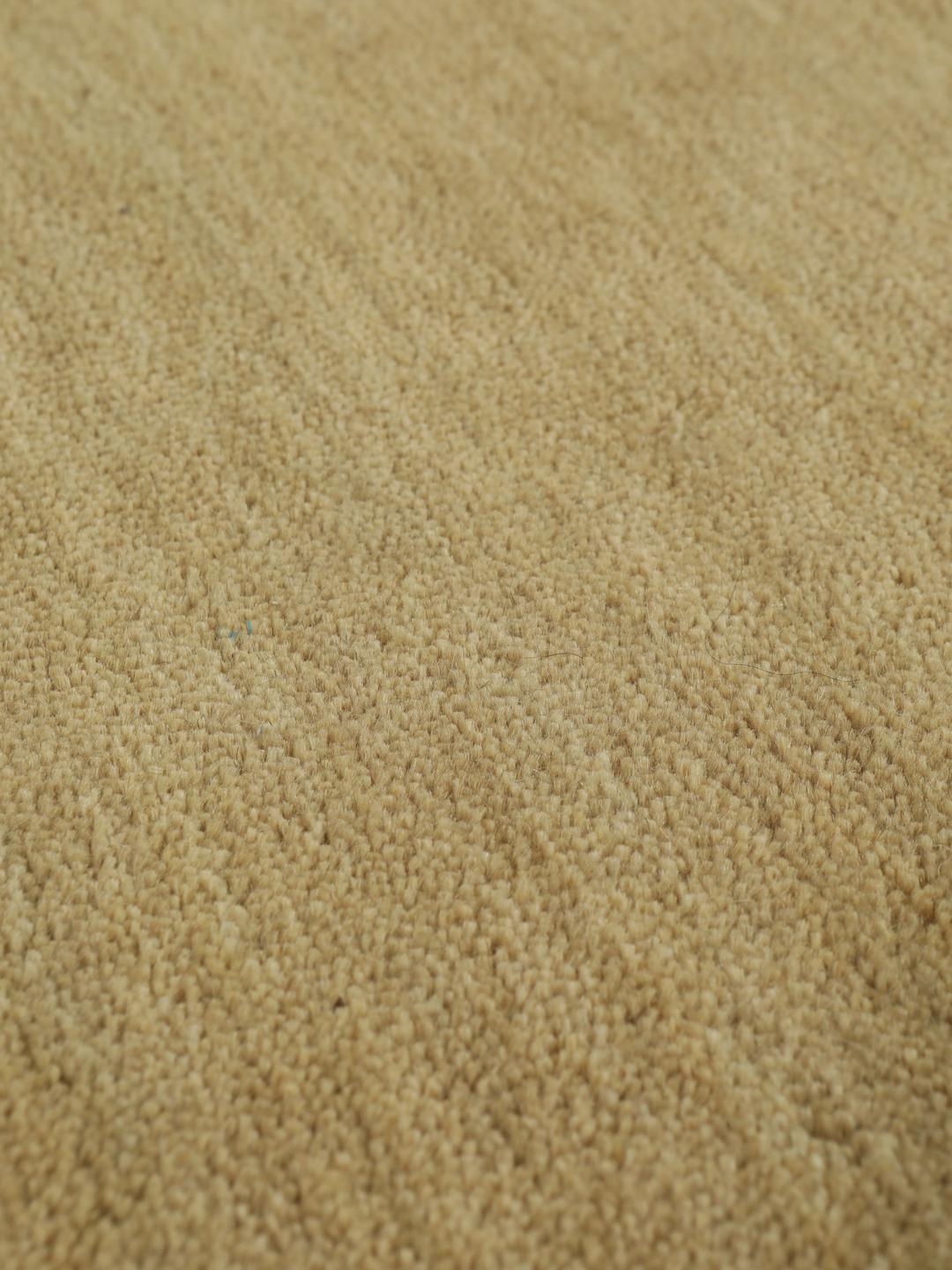 A round beige handloom rug with a soft wool pile