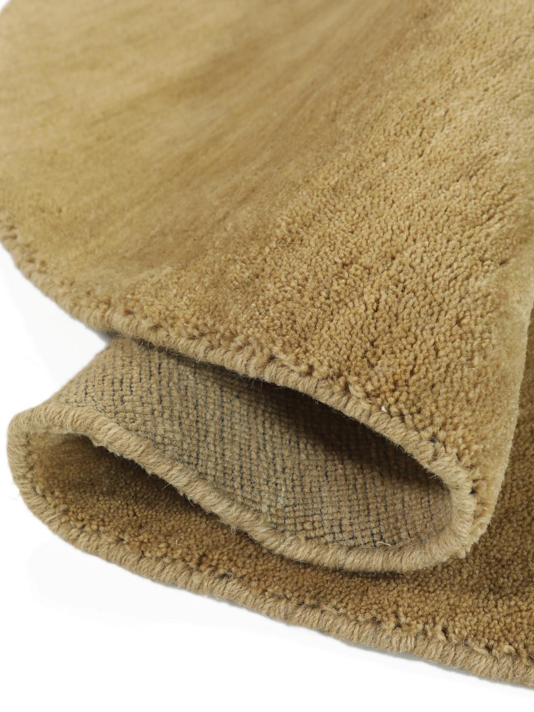 A round beige handloom rug with a soft wool pile