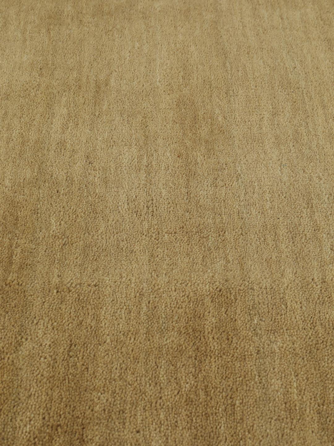 Um tapete redondo bege handloom com um pelo de lã macio