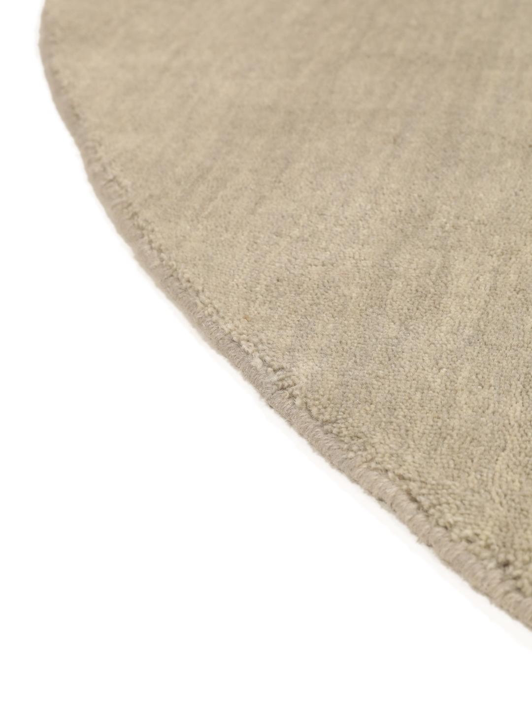 Rond beige handgeweven tapijt met een zachte textuur van wol