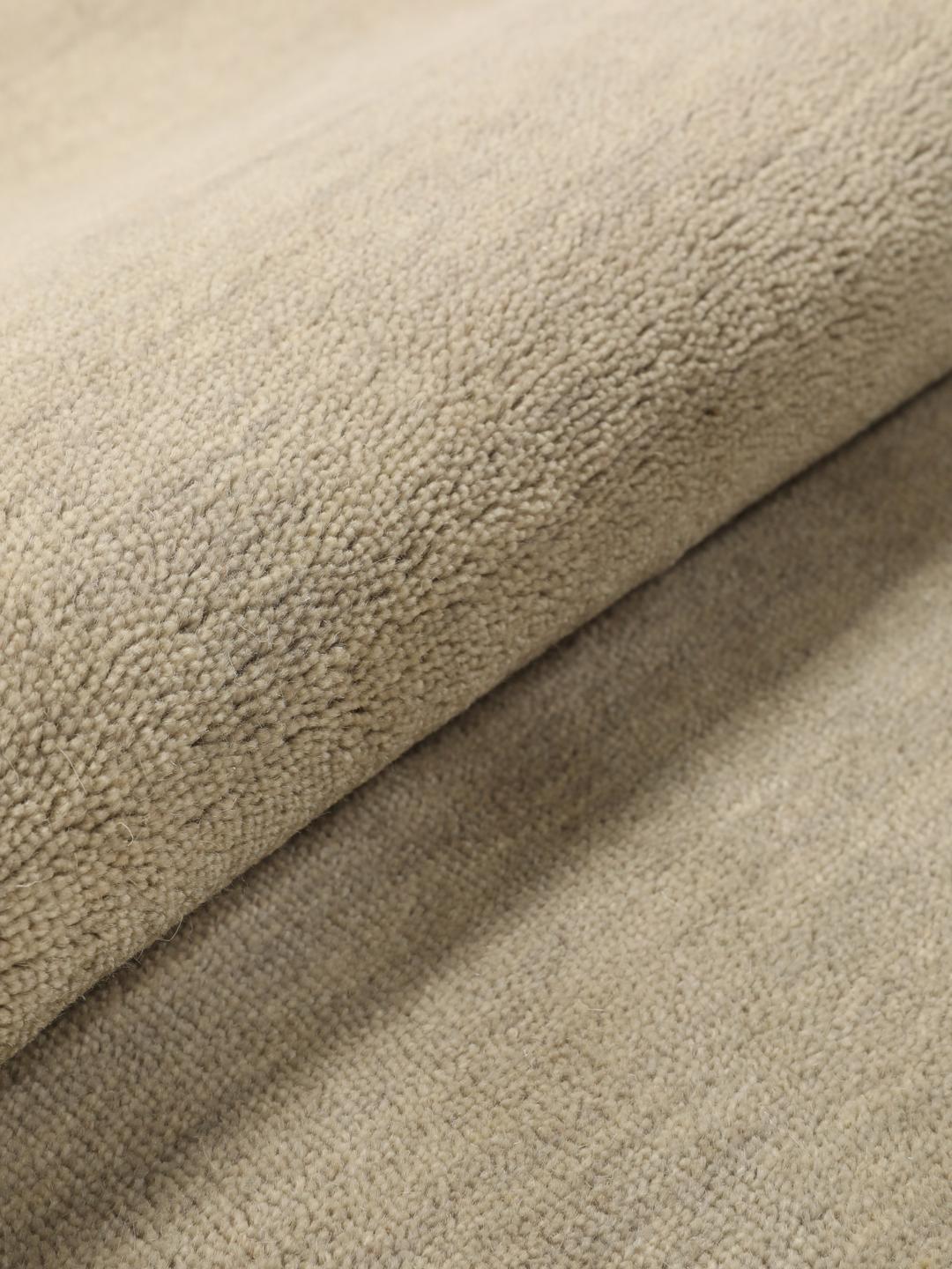 Rond beige handgeweven tapijt met een zachte textuur van wol