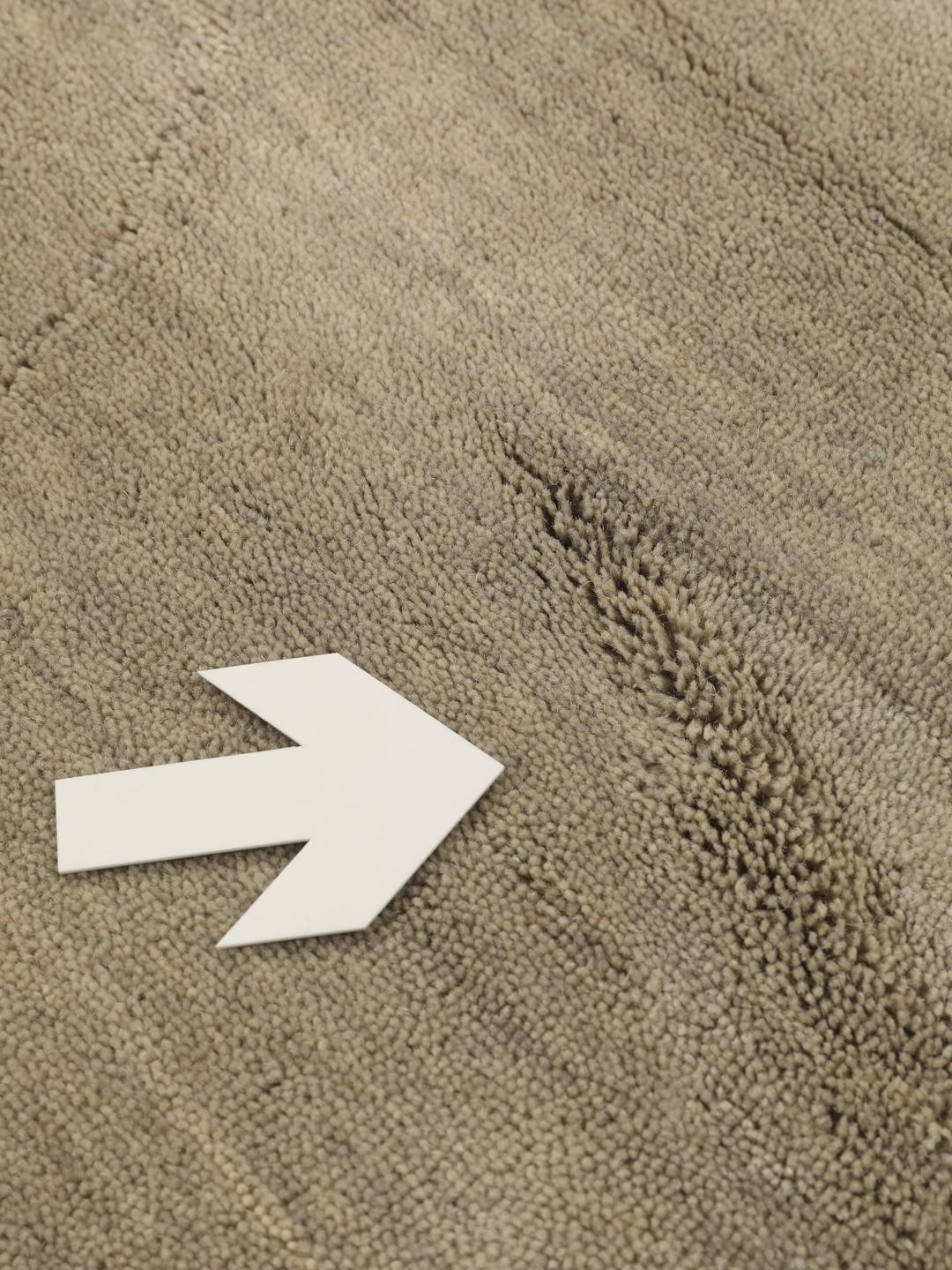 Rond beige handgeweven tapijt met een zachte textuur van wol