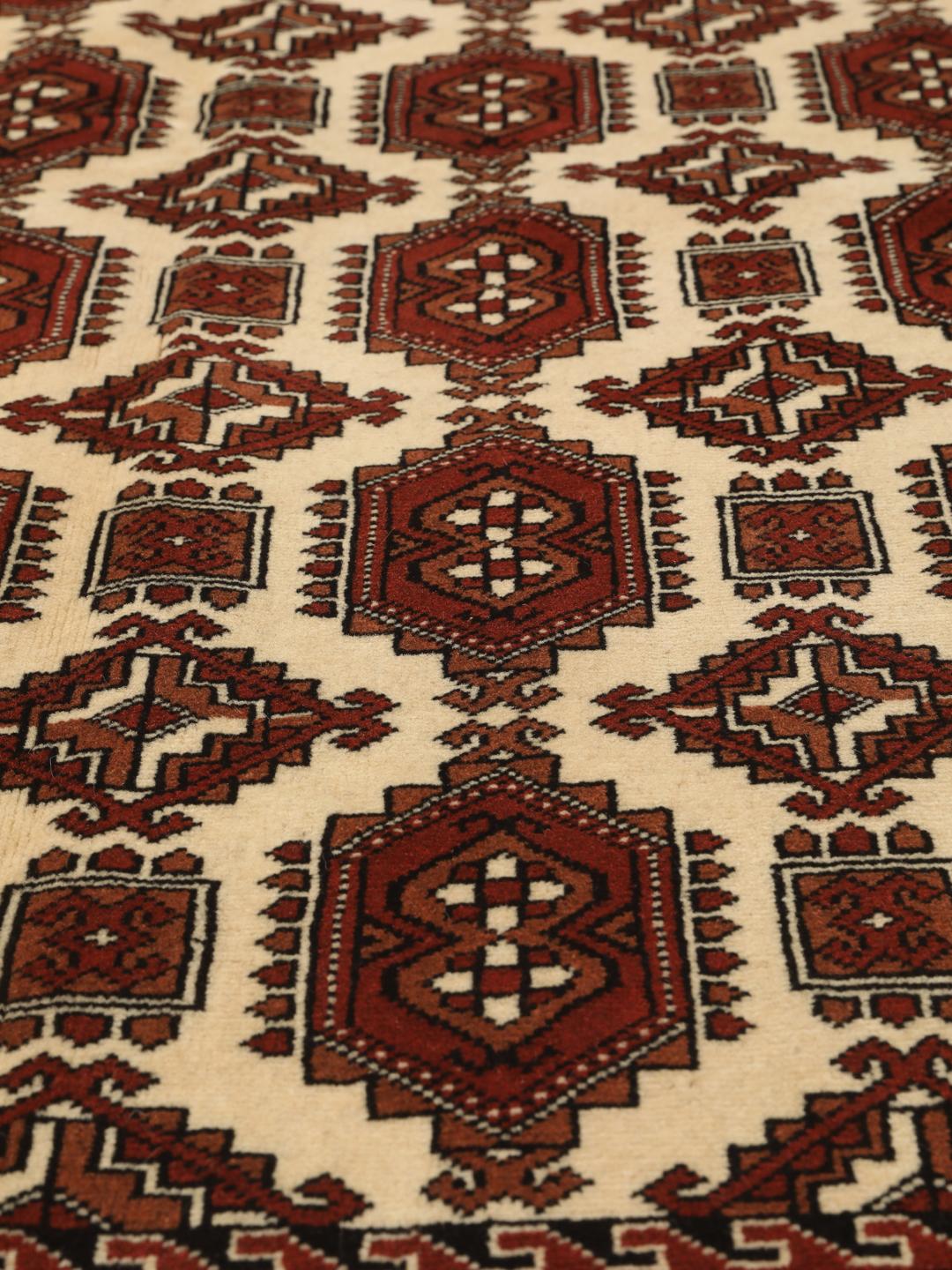 Hand-knotted Turkaman rug from the Middle East in red and cream tones